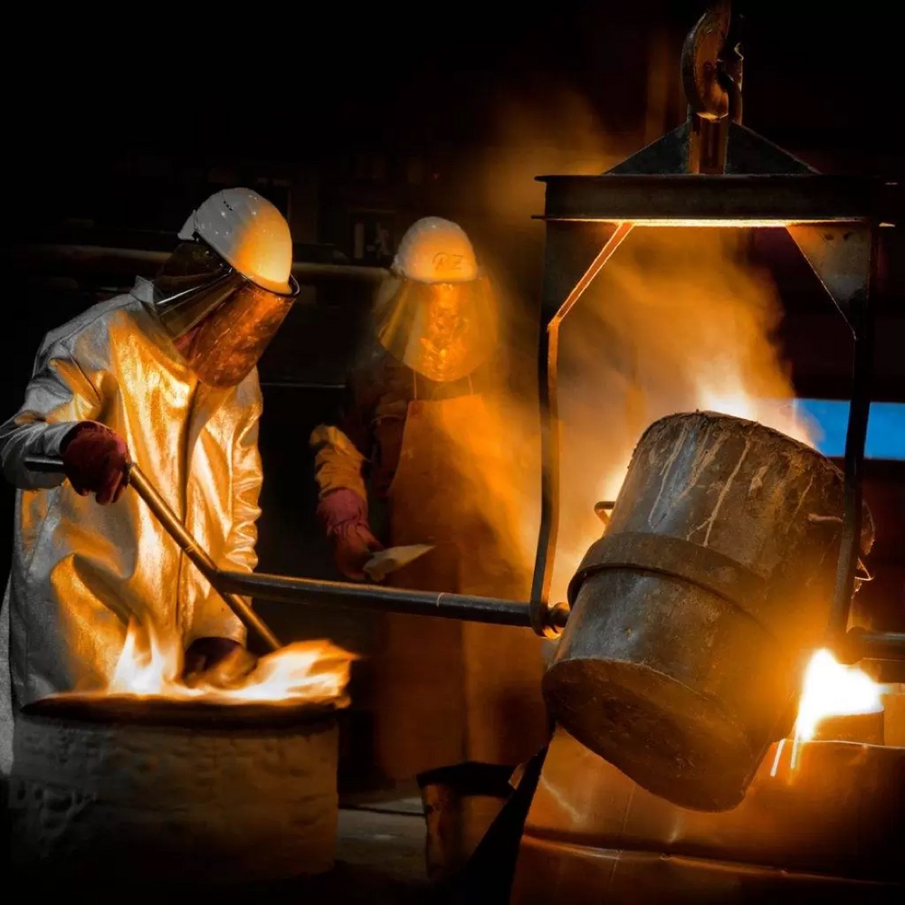 Equipo de fundición vaciando metal fundido en planta